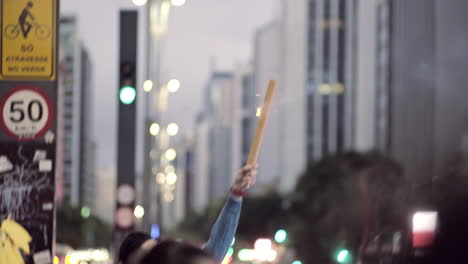 Man-Launching-Handhold-Fireworks-on-a-Grey-Evening-in-a-Huge-City