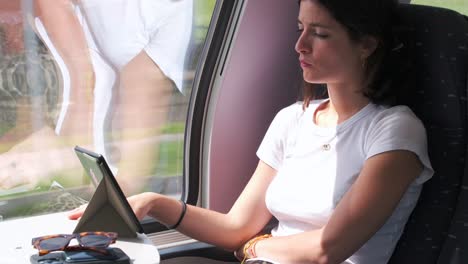 Mujer-Leyendo-Un-Libro-Electrónico-En-Tren,-Concentrada-Y-Tranquila-Durante-El-Viaje.