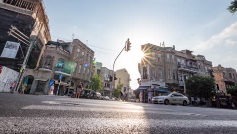 Zentrum-Von-Tel-Aviv---Verkehr-Und-Menschen,-Die-Bei-Sonnenuntergang-Zwischen-Den-Gebäuden-Vorbeigehen