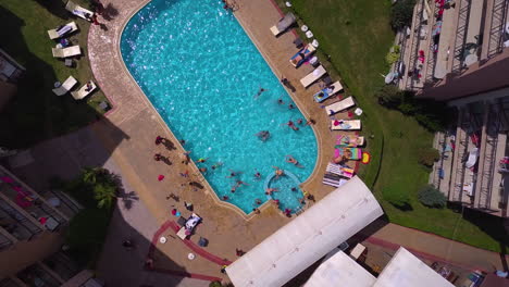 Vista-Superior-De-La-Toma-De-Drones-De-La-Piscina-En-El-Complejo-Hotelero-Con-Niños-Jugando