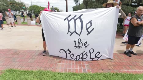 Patriota-Estadounidense-Sosteniendo-Una-Pancarta-Que-Decía-&quot;nosotros-El-Pueblo&quot;-En-Una-Manifestación-De-&quot;liberar-A-Nuestros-Patriotas&quot;-En-Tallahassee,-Con-Fines-Editoriales.