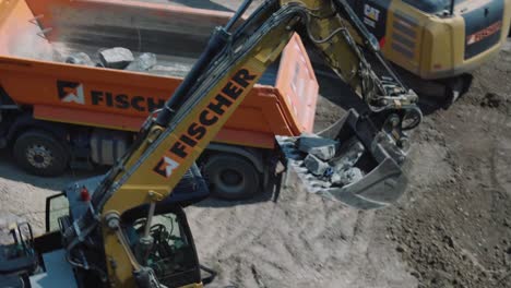 Bagger-Gräbt-Steine-Aus-Und-Lädt-Sie-Auf-Einer-Baustelle-In-Einen-LKW,-Nahaufnahme