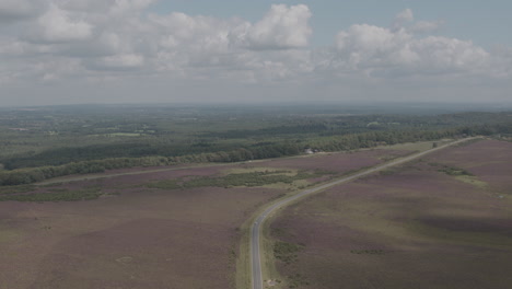 Aerial-Drone-Static-Shot-English-Countryside-with-Road-in-New-Forest-on-Sunny-Cloudy-Day