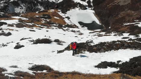 A-solo-trekker-trekking-through-a-snow-trail-in-a-sloppy-hill