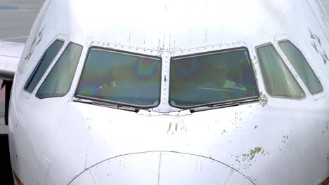 Close-up-shot-of-two-pilots-sitting-in-the-cockpit-of-a-Boeing-jet-waiting-to-push-back-from-San-Francisco-Airport-during-a-muggy-afternoon