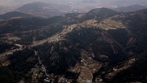 Aerial-drone-shot-of-mountain-range-of-pachuca-mexico-with-green-and-yellow-fields