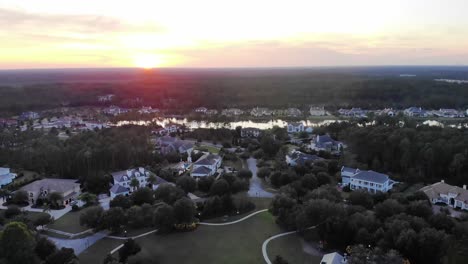 Vista-Aérea-Del-Barrio-Del-Norte-De-Florida-Bordeando-Bosques-Densos-Durante-La-Puesta-De-Sol