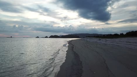 Luftaufnahme-Eines-4k-Paares,-Das-Bei-Sonnenuntergang-Einen-Abgelegenen-Strand-Entlangläuft,-Indonesien