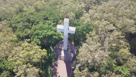 Aerial-Drone-rotating-Shot-of-Mt-Davidson-Cross-on-top-in-San-Francisco-surrounded-by-lush-green-trees-on-a-sunny-day