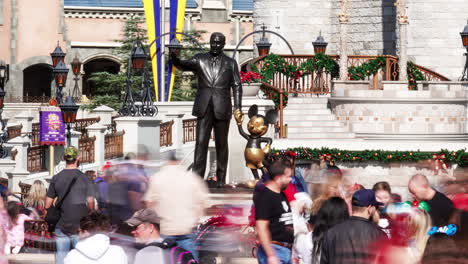 Lapso-De-Tiempo-De-Los-Asistentes-Al-Parque-Del-Reino-Mágico-De-Disney-Contemplando-La-Estatua-Del-Compañero-Con-Walt-Disney-Y-Mickey-Mouse-Frente-Al-Castillo-De-Cenicienta