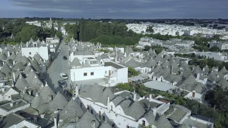 Beautiful-aerial-drone-footage-of-a-fourteenth-to-sixteenth-century-UNESCO-heritage-site-in-Alberobello,-at-the-South-of-Italy-showcasing-the-whitewashed-Trulli-and-their-handmade-symbolic-pinnacles