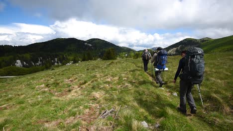 Three-people-hiking-alone-along-the-trail-in-the-mountains-on-a-sunny-day-in-Croatia