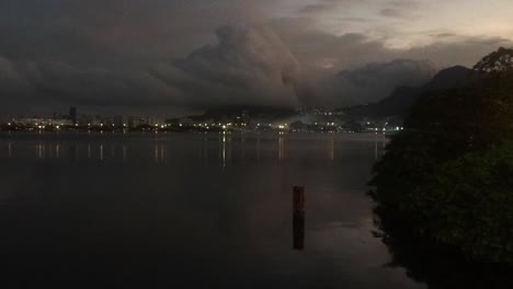 Lapso-De-Tiempo-Del-Fenómeno-Climático-Excepcional-De-Una-Nube-Tubular-Que-Llega-Desde-El-Océano-Golpeando-Las-Montañas-Costeras-En-Río-De-Janeiro-Vista-Desde-El-Lago-De-La-Ciudad