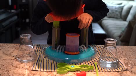 Niño-Haciendo-Un-Experimento-Científico-Burbujeante-Usando-El-Súper-Laboratorio-Del-Reactor-Líquido-De-Criaturas-De-Vaso