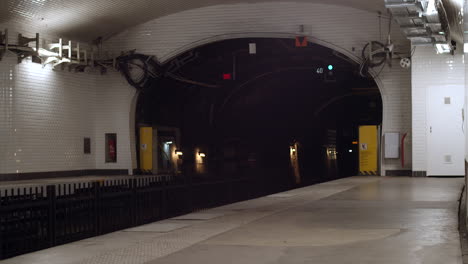 An-underground-metro-filled-with-people-comes-to-a-full-stop-on-the-other-side-of-the-tracks-in-Paris