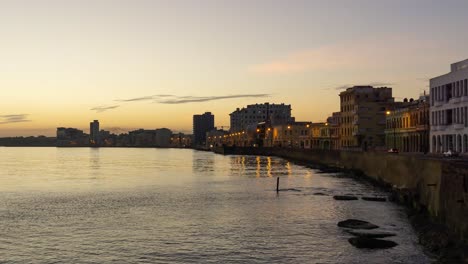 Hermosa-Vista-De-Lapso-De-Tiempo-De-La-Vieja-Ciudad-De-La-Habana,-Capital-De-Cuba,-Junto-A-La-Costa-Del-Océano-Durante-Un-Vibrante-Amanecer-Soleado-Y-Colorido