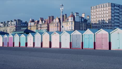 Man-walking-past-Brighton-and-Hove-beach-huts