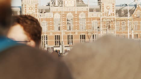 Timelapse-of-Amsterdam-Central-Station-with-people-walking-past-during-golden-hour-in-winter