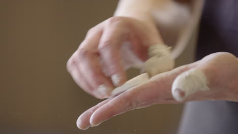 Closeup-of-caucasian-female-chalking-up-hands-before-weightlifting-workout