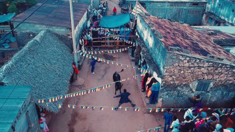 A-bull-being-released-in-the-city-during-a-wedding-in-the-Comoros-Africa-during-the-day-and-everyone-running-a-way-with-flags-blowing-in-the-wind