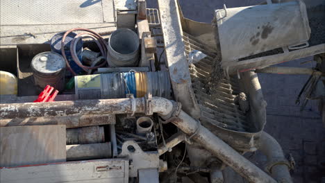 Slow-motion-closeup-panning-of-a-mixer-truck-dumping-fresh-concrete-into-a-boom-pumper-at-a-construction-site-in-Mexico