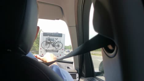 Slow-moving-traffic-from-the-view-of-the-driver-who-has-his-hands-rested-on-the-wheel