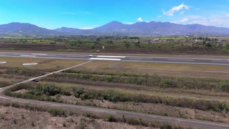 Luftaufnahme-Eines-Flugzeugstarts-In-Nayarit,-Mexiko,-Flugplätze-Und-Berghintergründe