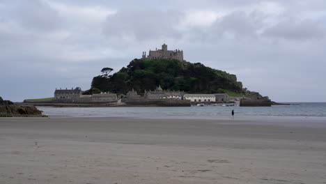 Einsame-Person-Rennt-Am-Strand-Zum-Meer-Von-Marazion-In-Cornwall,-Direkt-Vor-Dem-Mount-St.-Michael