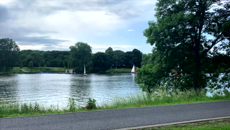 Time-lapse-of-an-electric-solar-boat-and-sailors-in-nice-weather-on-the-Aasee-in-Münster,-Germany