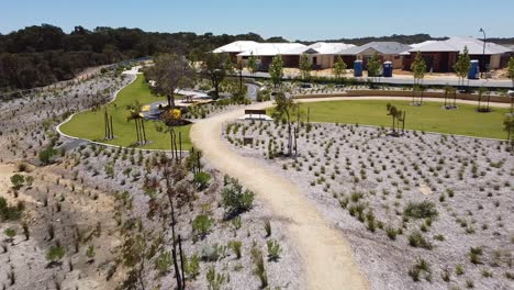 Descending-aerial-view-over-mountain-bike-park-with-learn-to-ride-area-in-new-housing-suburb