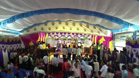 Aerial-view-of-a-modern-Indian-wedding-ceremony-with-people-enjoying,-dancing-and-waiting-in-a-queue-to-wish-the-couples