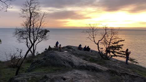 La-Gente-Se-Reúne-En-El-Acantilado-Para-Ver-La-Puesta-De-Sol-Sobre-El-Mar-En-Vancouver,-Posibilidad-Remota.