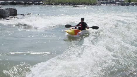 Un-Kayakista-De-Aguas-Bravas-Surfea-Una-Pequeña-Ola-De-Río