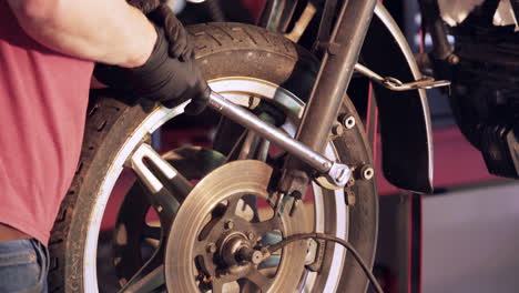 Cerca-De-Las-Manos-Usando-Una-Llave-Para-Aflojar-El-Perno-Durante-El-Desmontaje-De-La-Motocicleta