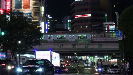 Autos-Und-Fahrräder,-Die-An-Der-Berühmten-Shibuya-kreuzung-In-Tokio,-Japan,-Vorbeifahren