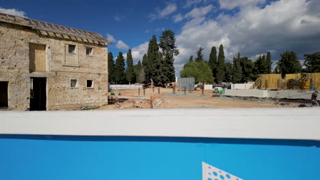 An-old-stone-building-under-renovation-in-Pafos,-Cyprus,-with-a-construction-site-in-the-foreground