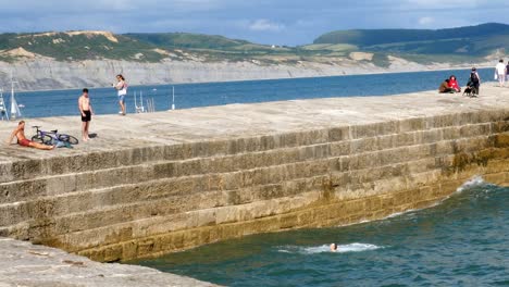 Ein-Teenager-Springt-Oder-Taucht-Von-Einem-Pier-Ins-Meer