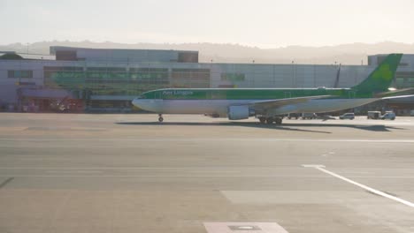 Handheld-slow-motion-shot-of-plane-at-San-Francisco-international-airport-during-golden-hour