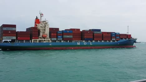 A-bulk-carrier-ship-with-a-deck-full-of-cargo-containers-transport-in-calm-open-sea-under-clear-skies