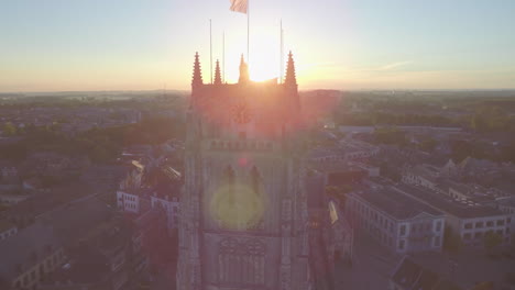 Luft-Zeitlupe:-Aufnahme-Eines-Kirchturms-Mit-Aufgehender-Sonne,-Die-Sonnenstreifen-Erzeugt