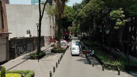 Aerial-tracking-shot-of-lorry-driving-through-tight-road-in-la-condesa