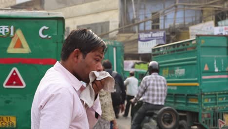 Middle-aged-man-sweating-on-a-crowded,-old-Delhi-Chandni-Chowk-street-on-an-extremely-hot-Indian-summer-day