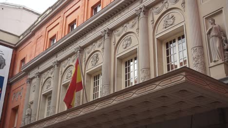 Toma-Estática-De-La-Bandera-Española-Ondeando-Fuera-Del-Teatro-De-La-Zarzuela-En-Madrid,-España.