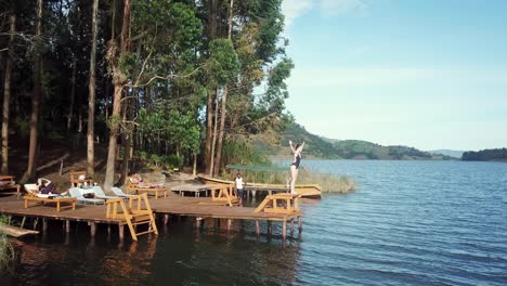 Buceo-Turístico-Desde-La-Plataforma-De-Madera-Con-Tumbonas-En-El-Lago-Bunyonyi,-Uganda