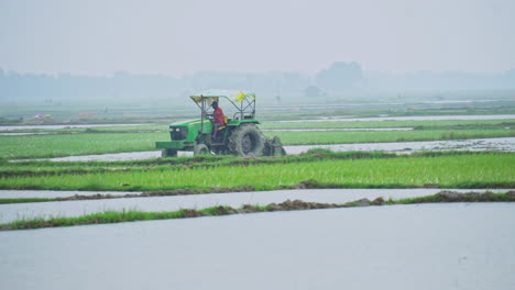 Indian-farmer-plowing-agricultural-field-with-the-tractor-in-the-rainy-season