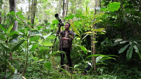 Fotógrafo-De-Vida-Silvestre-Usando-Teleobjetivo-Con-Ropa-De-Camuflaje-Fotografiando-Vida-Salvaje-Usando-Trípode