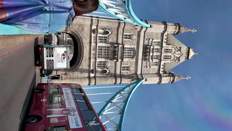 Vertical-view-of-Tower-Bridge,-bustling-with-road-traffic-and-pedestrians-on-sidewalks,-vibrant-daytime-scene,-the-concept-of-urban-connectivity-and-activity