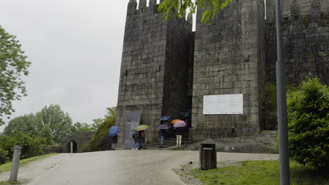 Touristen-Betreten-Die-Burg-Von-Guimaraes-Zwischen-Zwei-Türmen-In-Der-Mauer,-Portugal