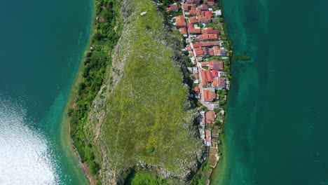 Vegetación-De-Península-Pedregosa,-Aguas-Color-Esmeralda-Del-Pintoresco-Lago-En-El-Antiguo-Pueblo-Albanés-De-Lin