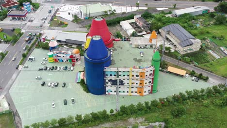 Toma-Aérea-De-Gran-ángulo-Que-Captura-La-Atracción-Turística-Colorida-Fábrica-De-Crayones-De-Arte-Afortunado,-Centro-De-Experiencias-De-Bricolaje-Para-Niños-Y-Familias-Y-Paisaje-Urbano-En-El-Condado-De-Yilan,-Taiwán